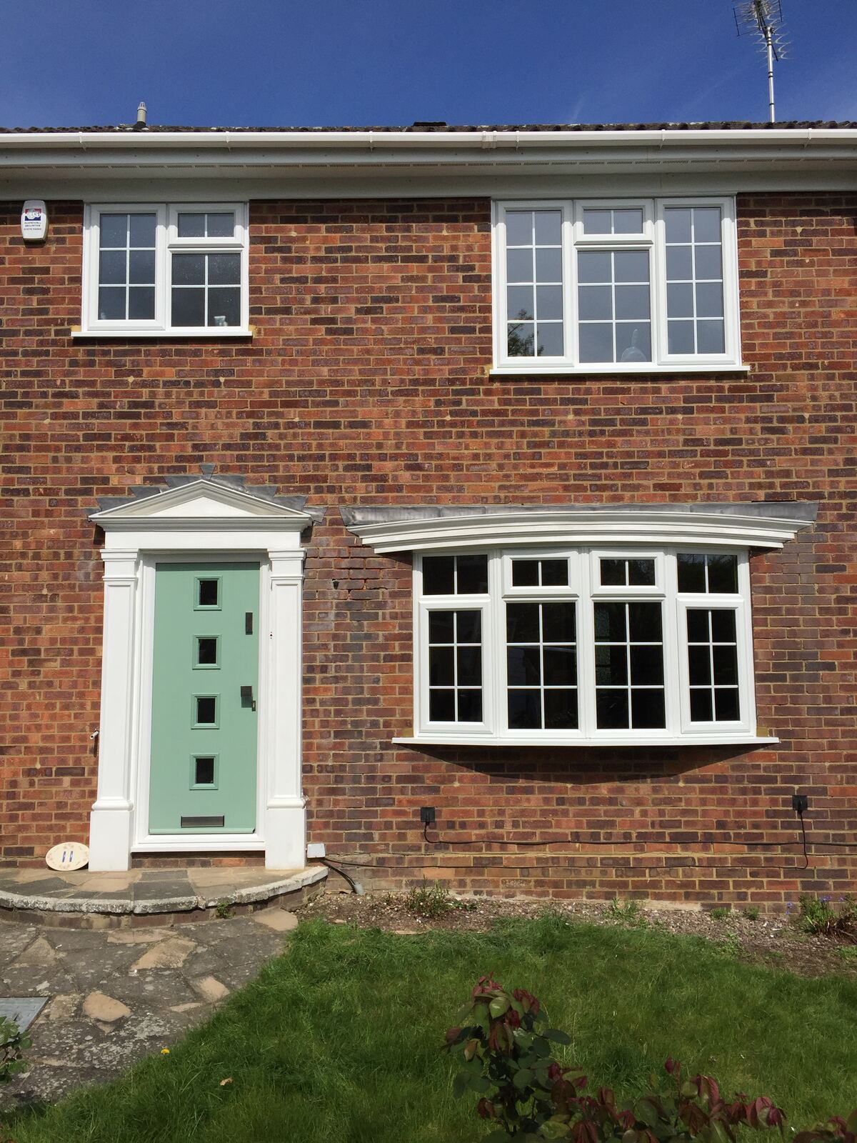 Sage green composite front door with uPVC Georgian bar windows